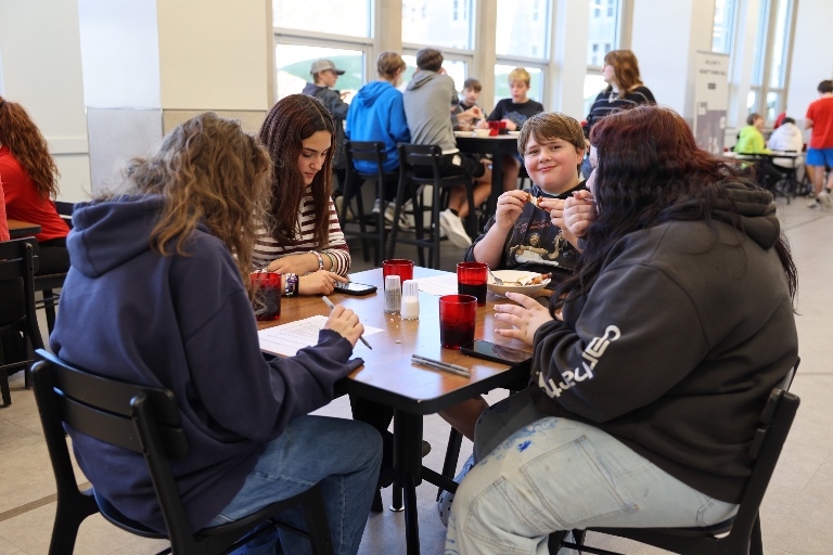 A student smiles while noticing he's being photographed